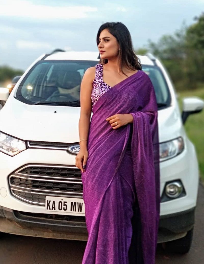 Deepika Das posing with her hatchback car