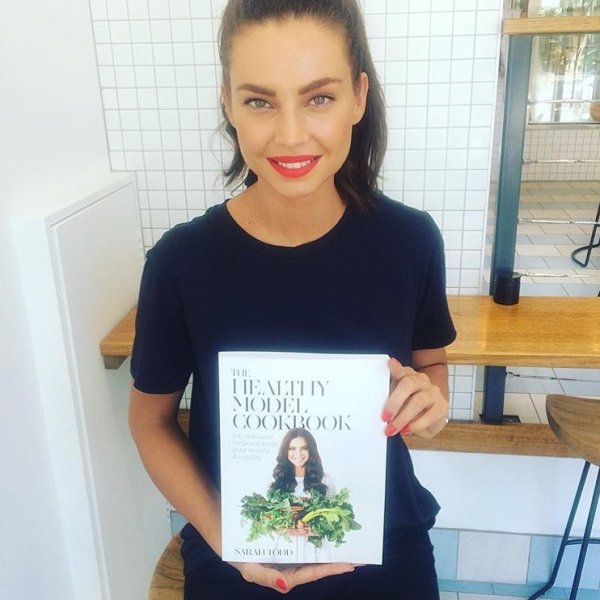Sarah Todd showing her first book The Healthy Model Cookbook