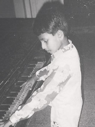 A childhood picture of Mithoon while playing piano