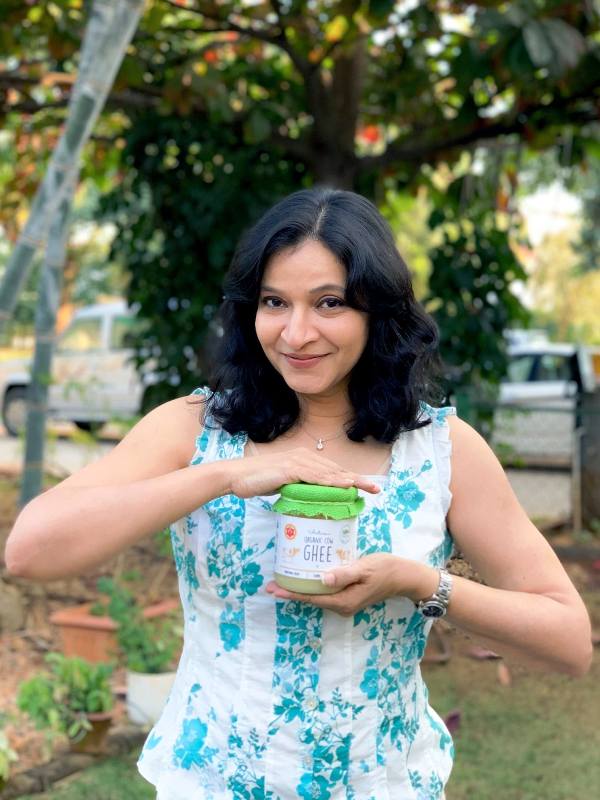 A photo of Manjula with the organic products that she sells on her website