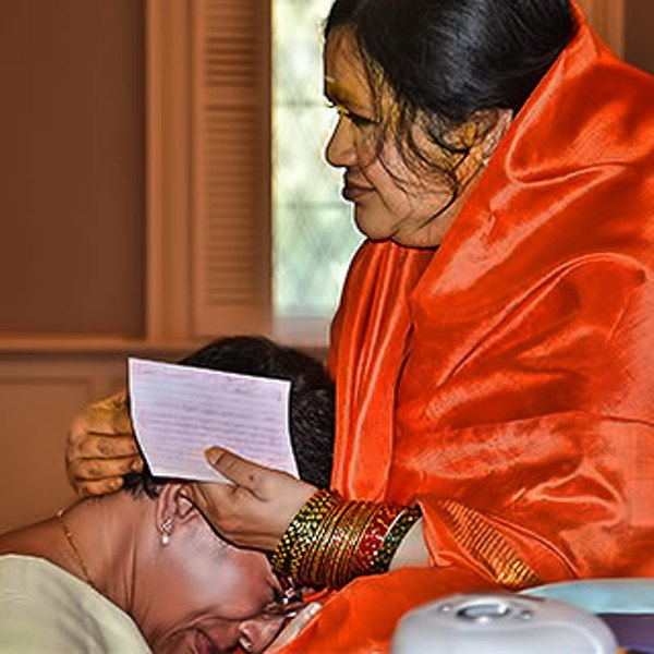 Amma Karunamayi blessing a devotee while they cry on her lap
