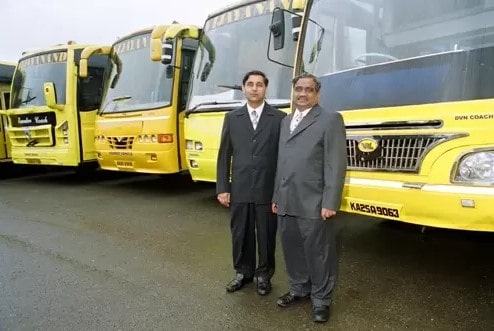 Anand Sankeshwar and Vijay Sankeshwar standing in front of the trucks owned by VLR Logistics Ltd