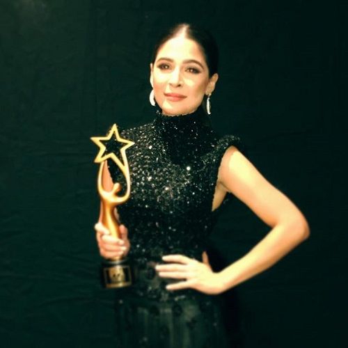 Ayesha Omar holding her award