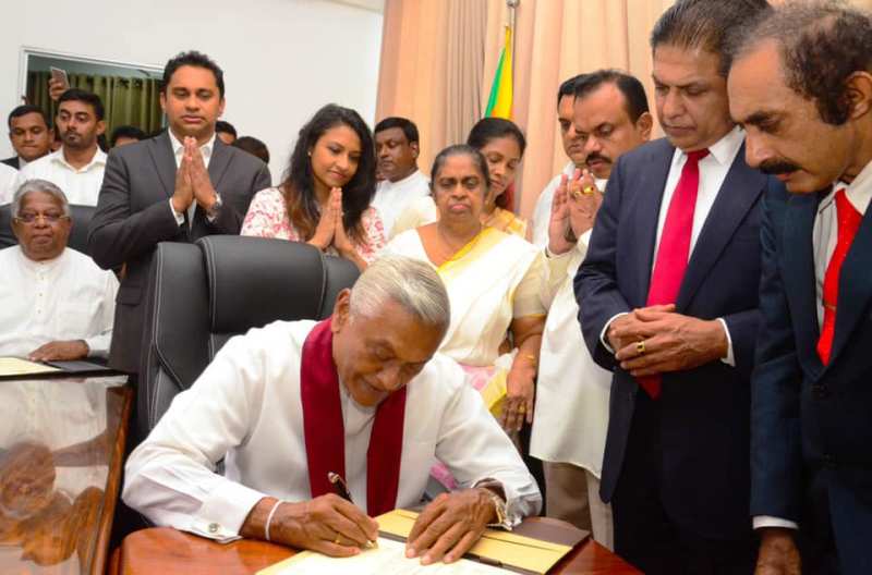 Chamal Rajapaksa signing a document after swearing in as the Minister of Irrigation
