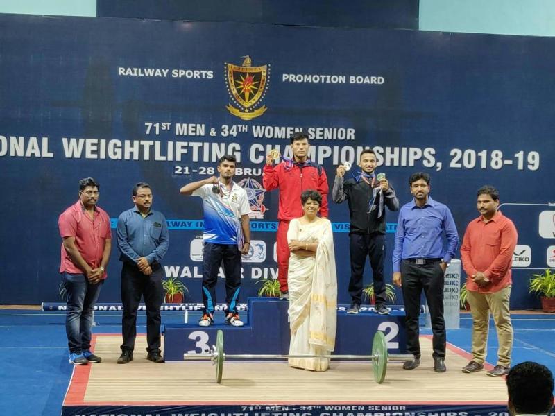 Chanambam Rishikanta Singh (in red tracksuit) on the podium after winning gold in the 71st Men Senior National Weightlifting Championships