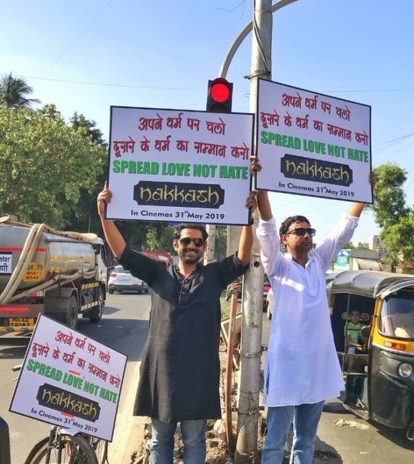 Enamulhaq poses with co-star Sharib Hashmi holding a hoarding on the road to promote his film 'Nakkash'
