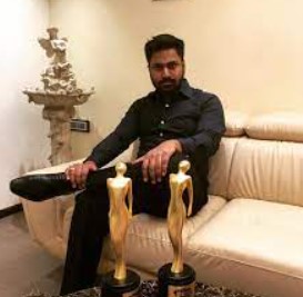 Mithoon posing with his awards