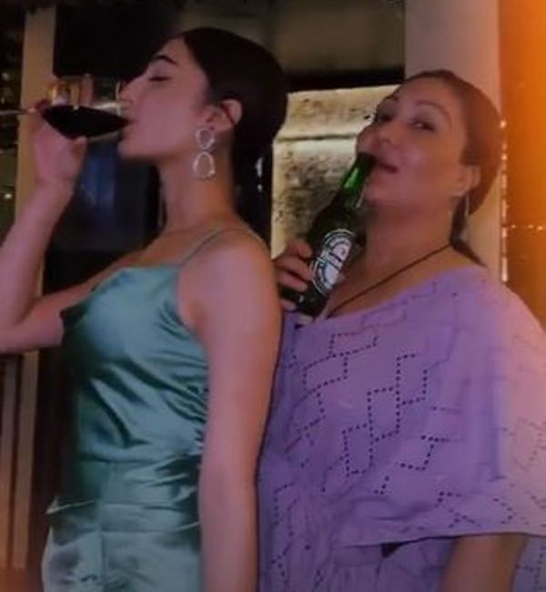 Oviya Darnal (left) consuming wine, along with her mother, Rekha Darnal