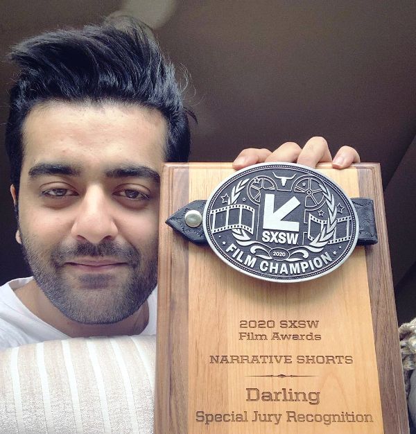 Saim Sadiq holding the SXSW award that his directed short film Darling received