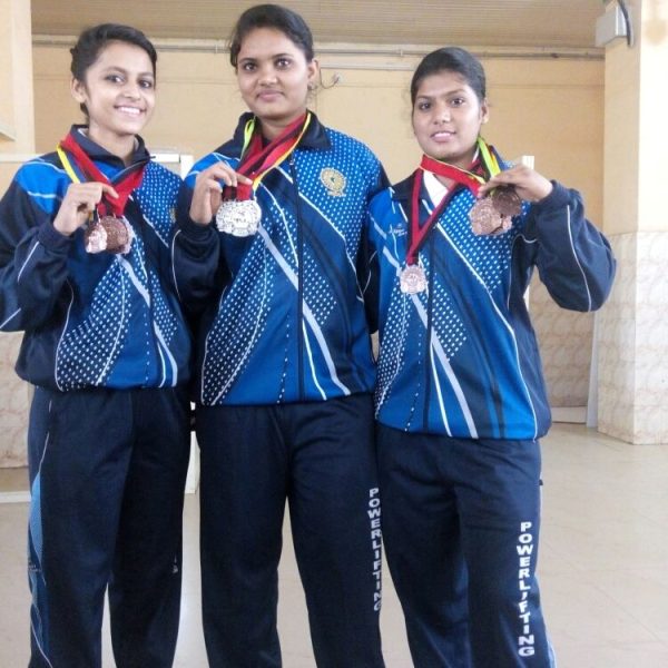 Usha Kumara (center) after winning a medal in Powerlifitng competition
