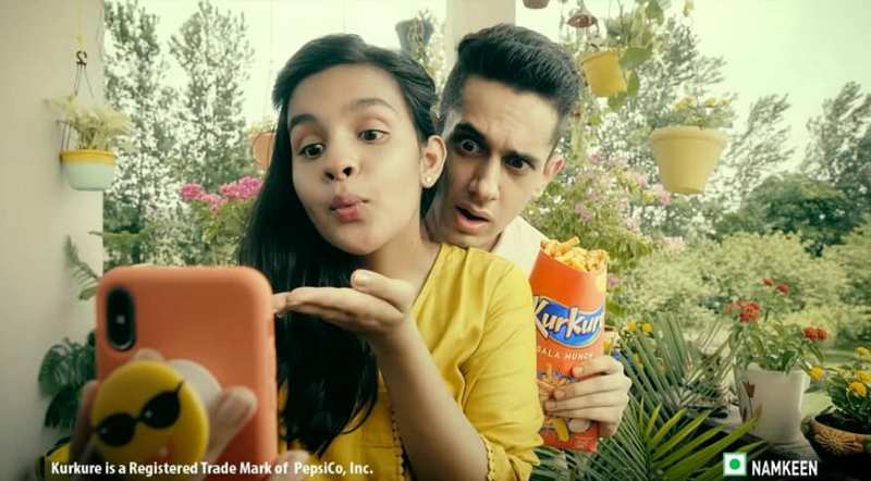Anupriya Caroli, along with a co-actor, in the television commercial for Kurkure