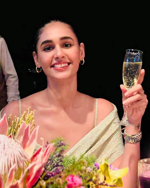 Hasleen Kaur holding a glass of champagne