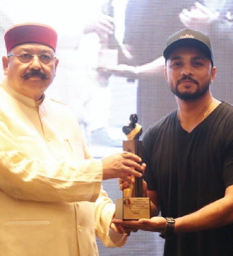 Raftaar receiving Dadasaheb Phalke International Film Festival Award