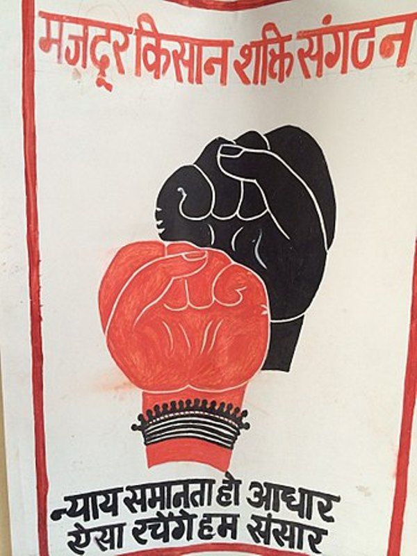 The poster of Mazdoor Kisan Shakti Sangathan featuring the MKSS symbol; a red and black emblem with one male and one female fist, raised in unison