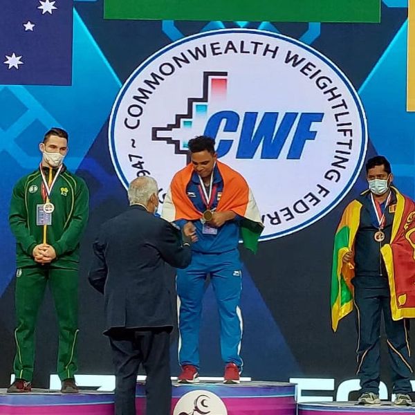 Ajay Singh (in centre) after winning gold in the 2021 Commonwealth Weightlifting Championships