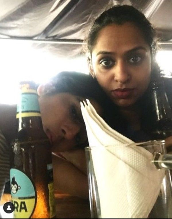 Nitya Mathur posing with a bottle of beer