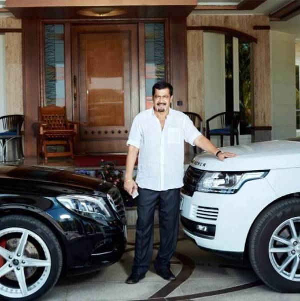 A photo of Muthappa Rai in between his Mercedes-Benz S-Class and Land Rover Range Rover