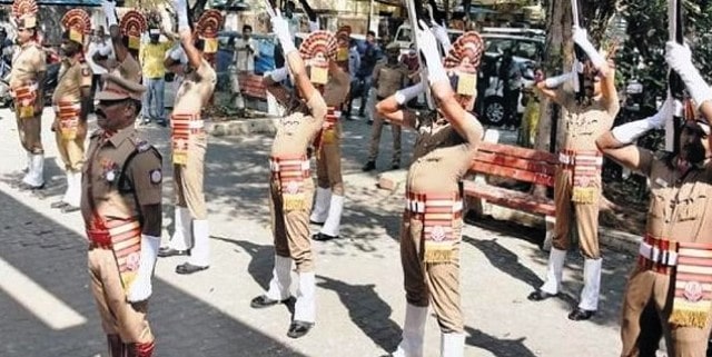 A photo of Tamil Nadu police personnel giving a gun salute during the cremation of Vani Jairam