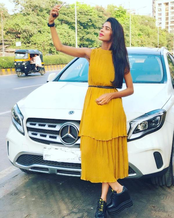 Tanu Chandel posing with her car