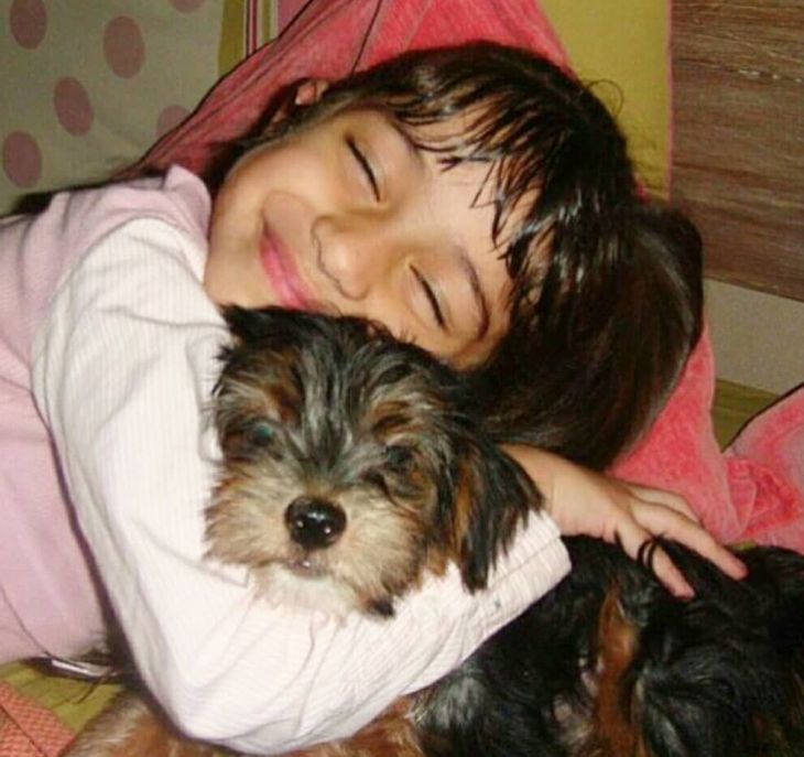 A childhood picture of Rysa hugging a dog