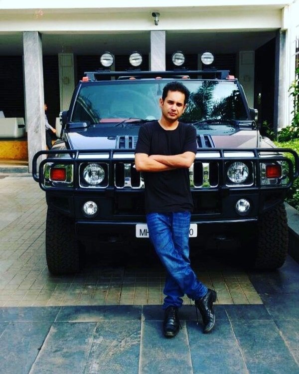 A photo of Pradyot standing in front of his Hummer H2