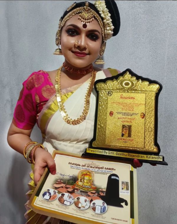 Arya Parvathy posing with her Dakshinamoorthi Vayalar Puraskaram Award by the Chenkal Maheswaram Temple in Trivandrum