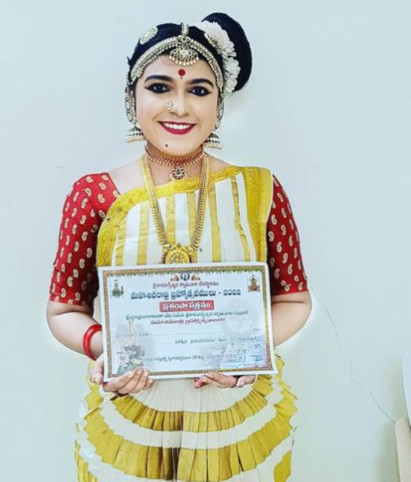 Arya Parvathy posing with her certificate, which she received for her performance at the Kalahasthi Temple in Andhra Pradesh in 2022