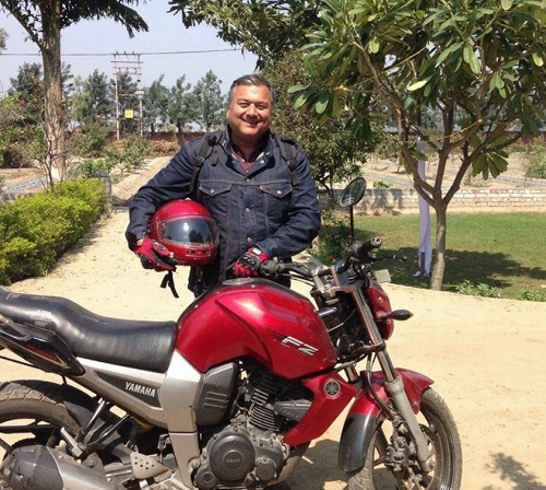 Peepal Baba posing with his motorcycle