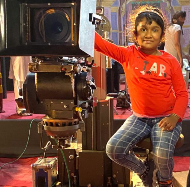 Vanshika Kaushik posing with a movie camera during her visit to a shooting set
