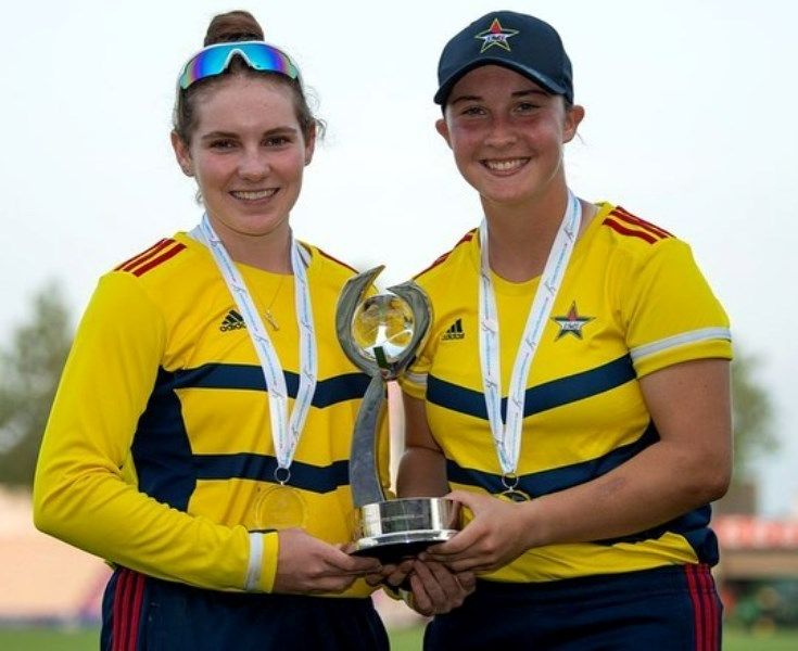 A photograph of Alice Capsey and her teammate with the Charlotte Edwards Cup