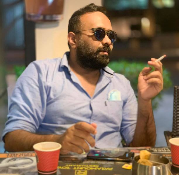 A photograph of Omar Lulu smoking a cigarette