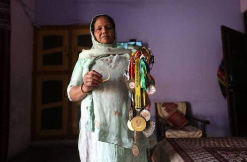 A picture of Deepak Boxer's mother holding his medals