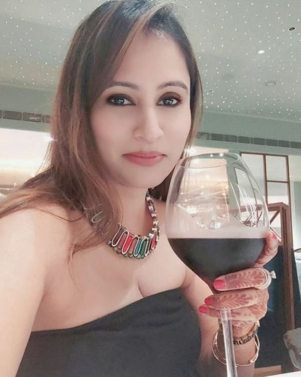 Aakshi Mathur holding a glass of wine