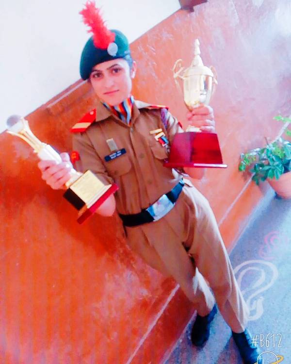 Baljeet Kaur holding the awards that she received in the NCC