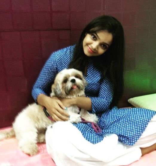 Nitya Shetty posing with a dog