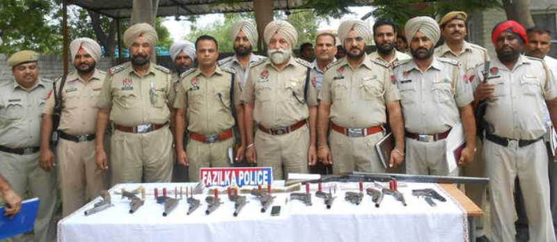 Police personnel displaying recovered weapons in Abohar, Punjab