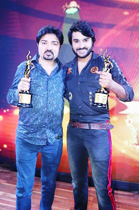 Pradeep with his father posing for a photo after receiving Bhojpuri Film Award in 2019