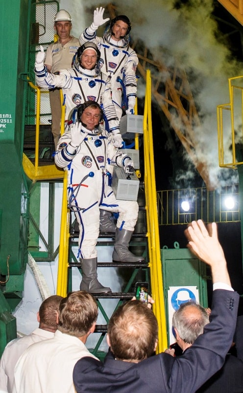 Russian scientists waving at Gregory (standing on top) and other astronauts
