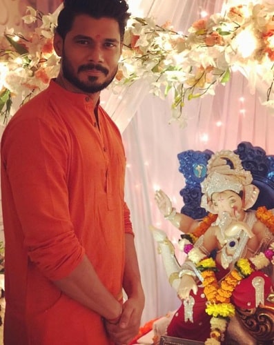A picture of Avinash Dwivedi with an idol of Lord Ganesha