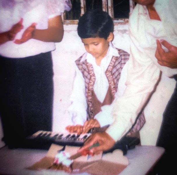 Childhood picture of Mayur playing the piano