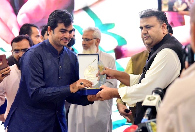 Fawad Chaudhry (right) giving an award