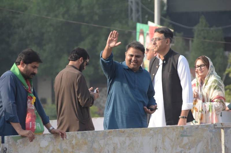 Fawad Chaudhry waving his hand to his supporters during a political campaign rally