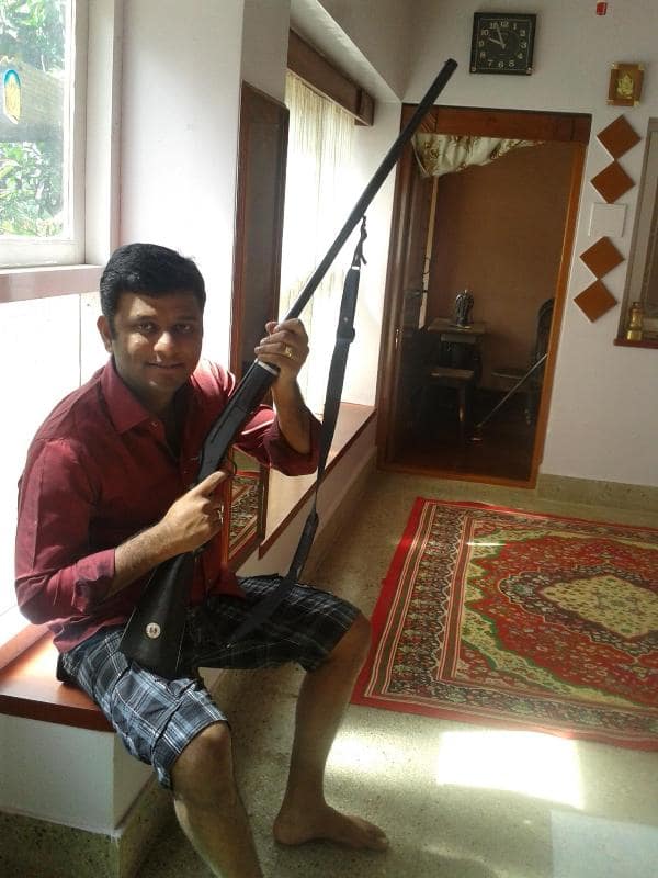 H. P. Swaroop posing for a photo with his double-barrel shotgun