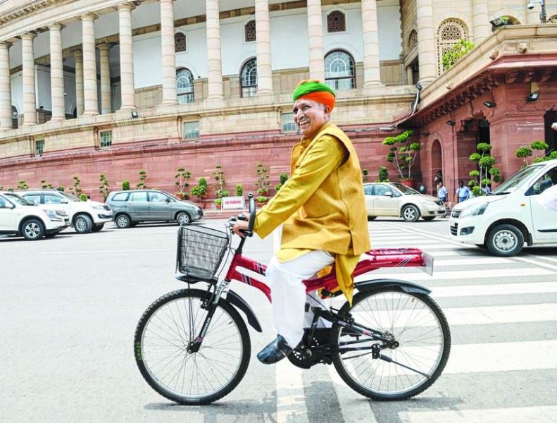 Meghwal riding a cycle outside parliament in his trademark Rajasthani outfit