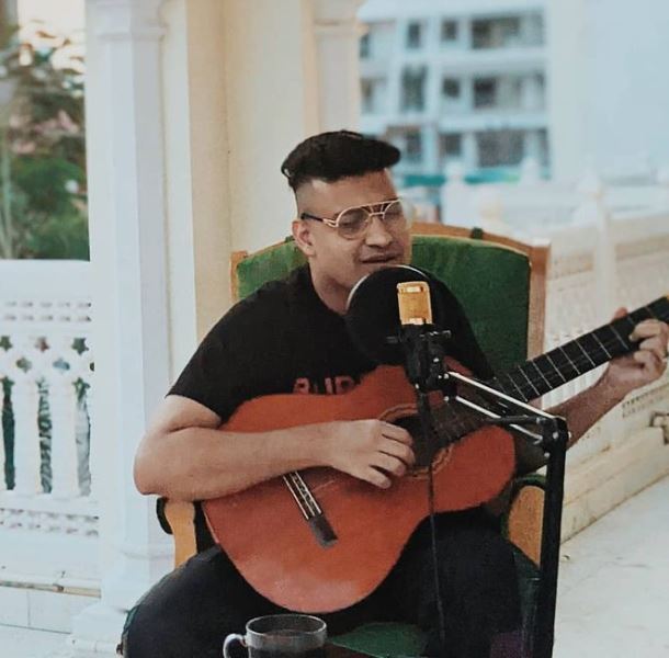 Shashwat Sachdev singing and playing the guitar