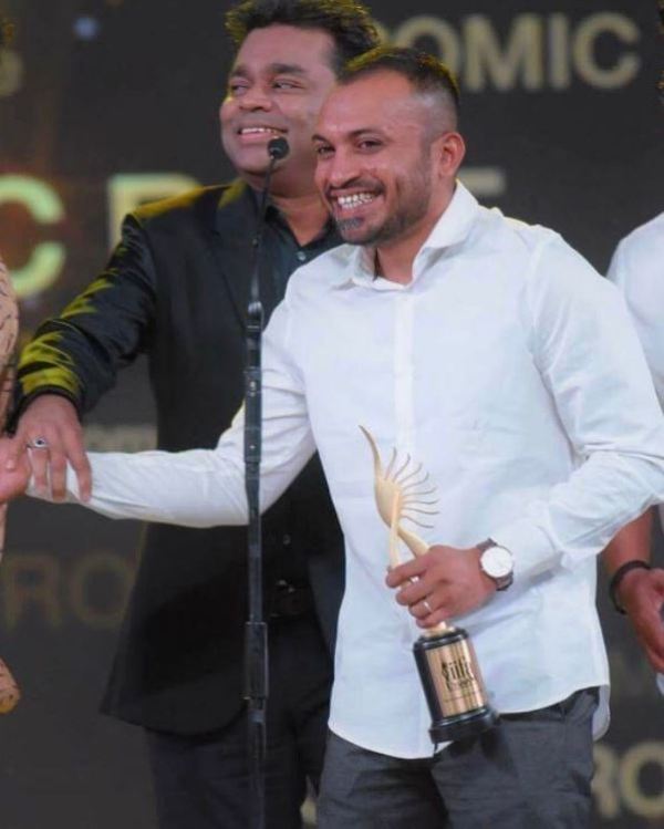 Soubin Shahir while receiving an award under the category of Performance In A Comic Role for the film 'Charlie' at 2nd IIFA Utsavam