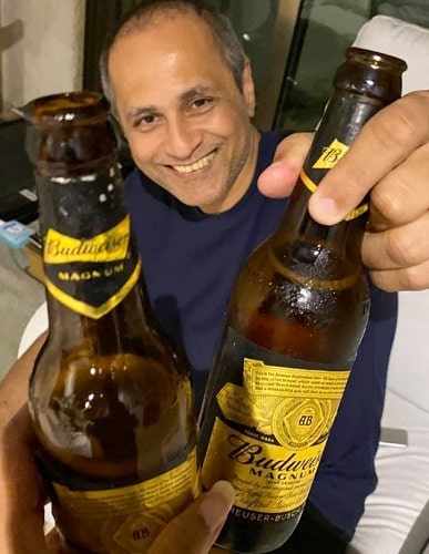 Vipul Amrutlal Shah holding a bottle of beer