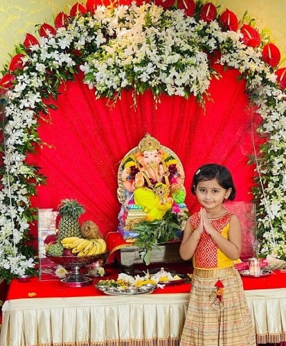 A picture of Myra Vaikul with an idol of Lord Ganesha