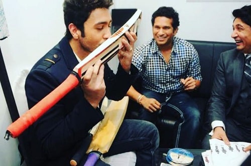 Adhyayan Suman kissing the bat gifted to him by Sachin Tendulkar with Sachin's autograph on it