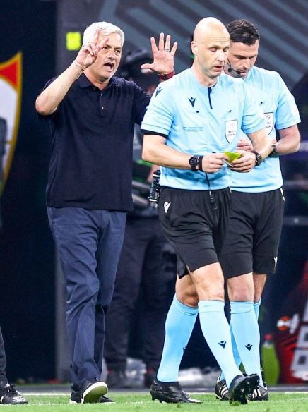 Anthony Taylor refereeing in the Sevilla FC vs AS Roma final match while AS Roma manager Jose Mourinho mocks him by making a gesture